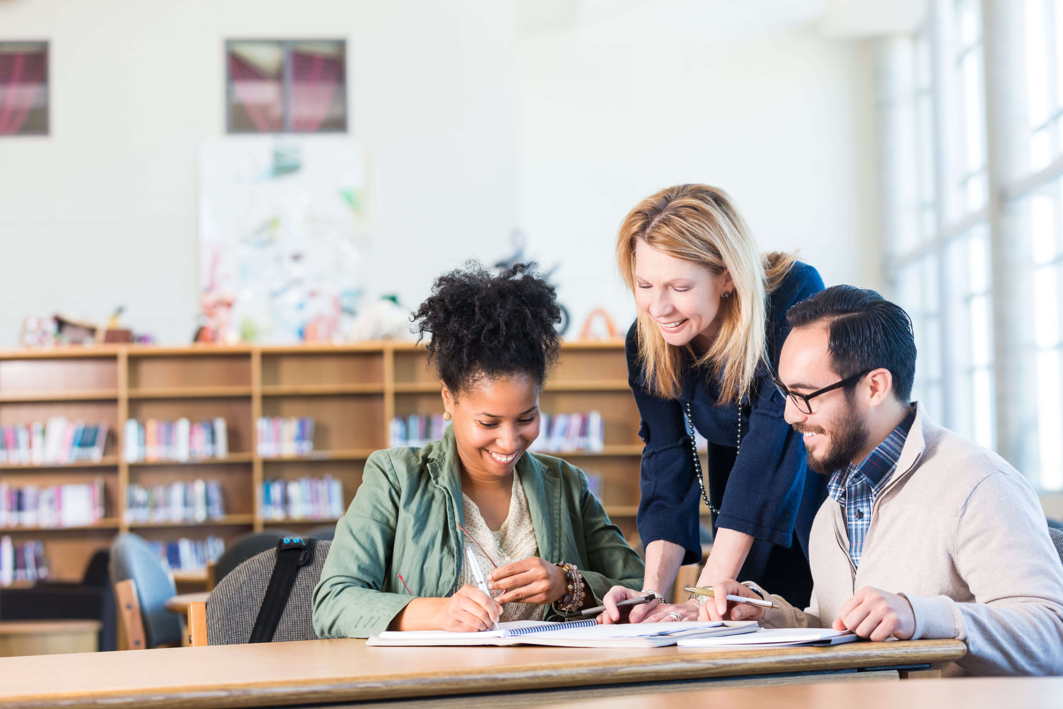 Diverse study group of adults working in large college library